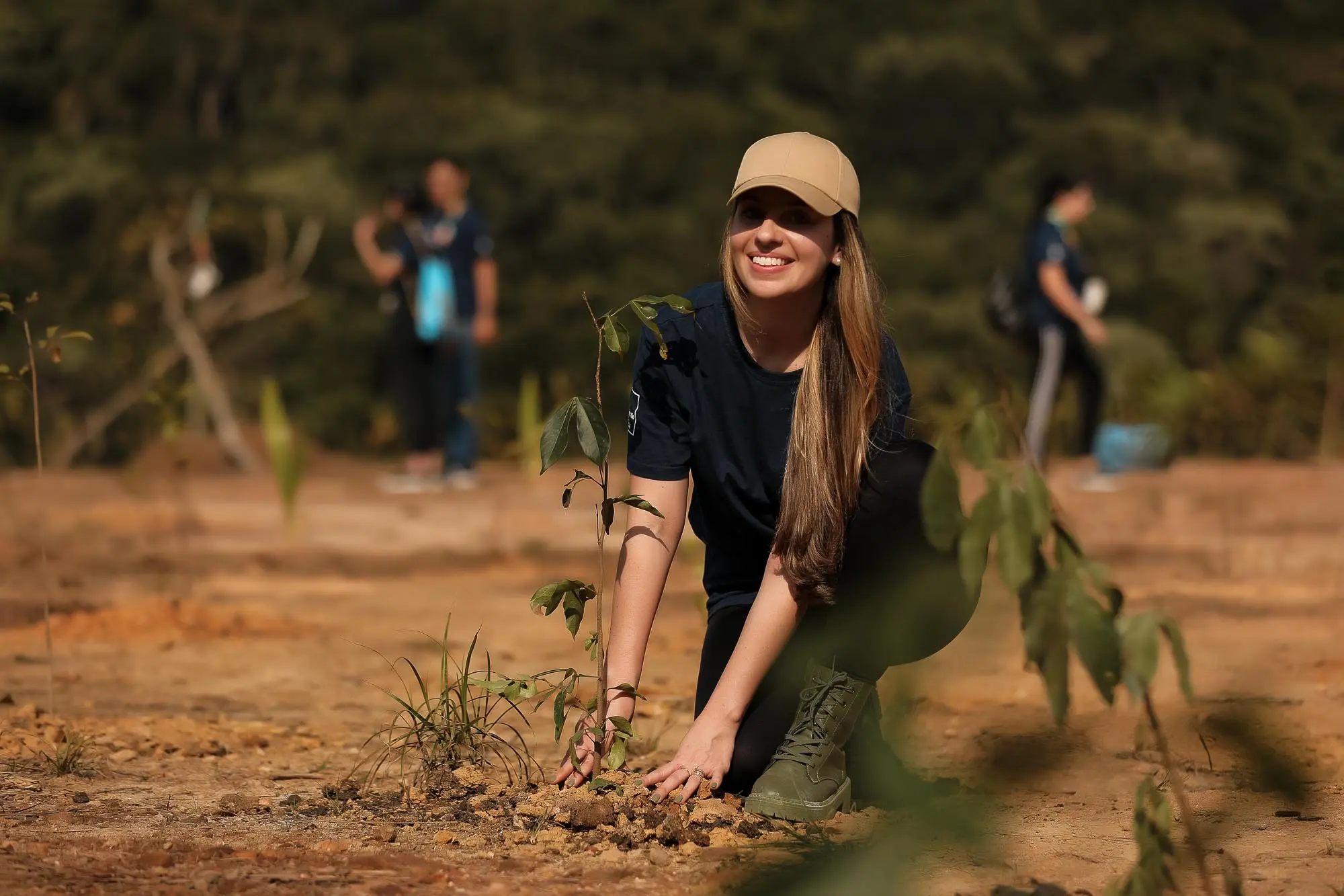 colaboradora da DC plantando uma árvore na campanha do Plantio